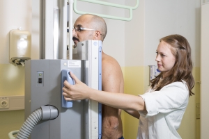 Röntgenassistentin behandelt stehenden Patienten
