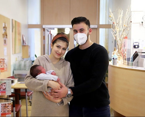 Neujahrsbaby am Arm seiner Eltern in der Klinik Hietzing