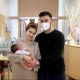 Neujahrsbaby am Arm seiner Eltern in der Klinik Hietzing