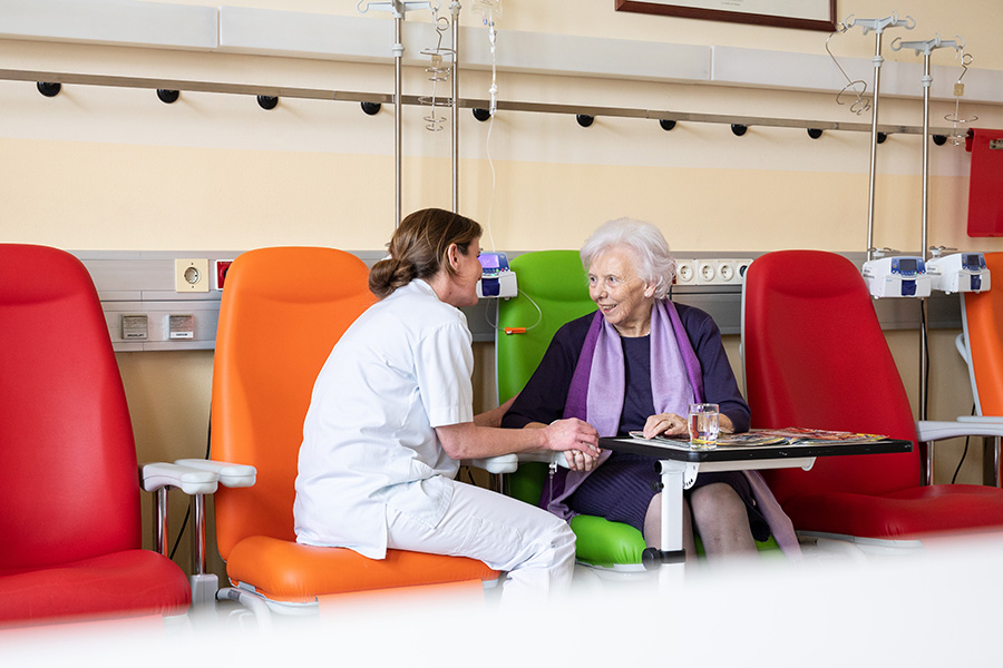 Pflegerin spricht mit einer älteren Patientin