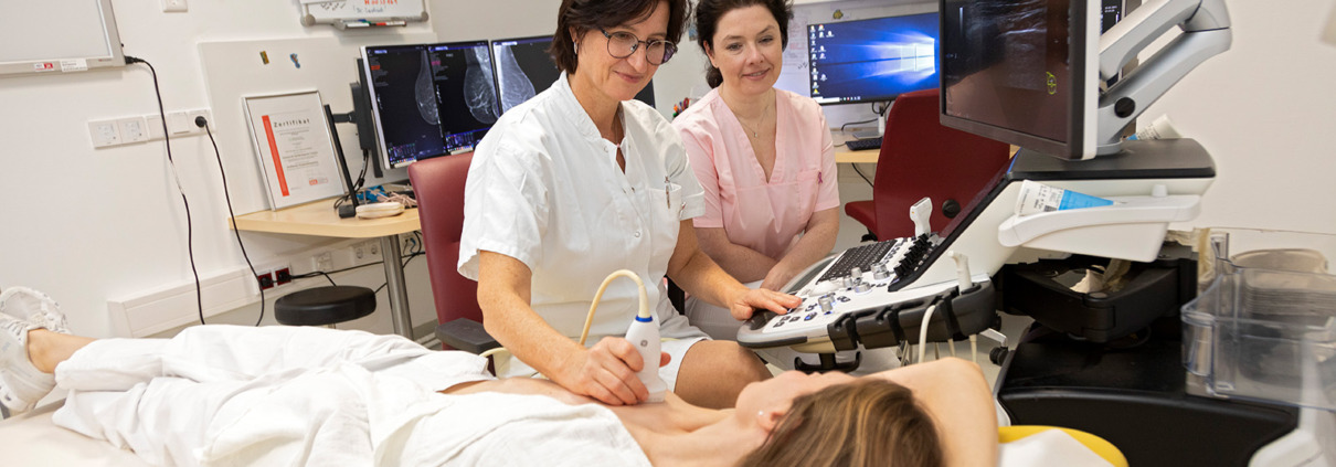 KHI PK Mammographie - Frau in Behandlung bei Brust-Ultraschall mit Ärztinnen